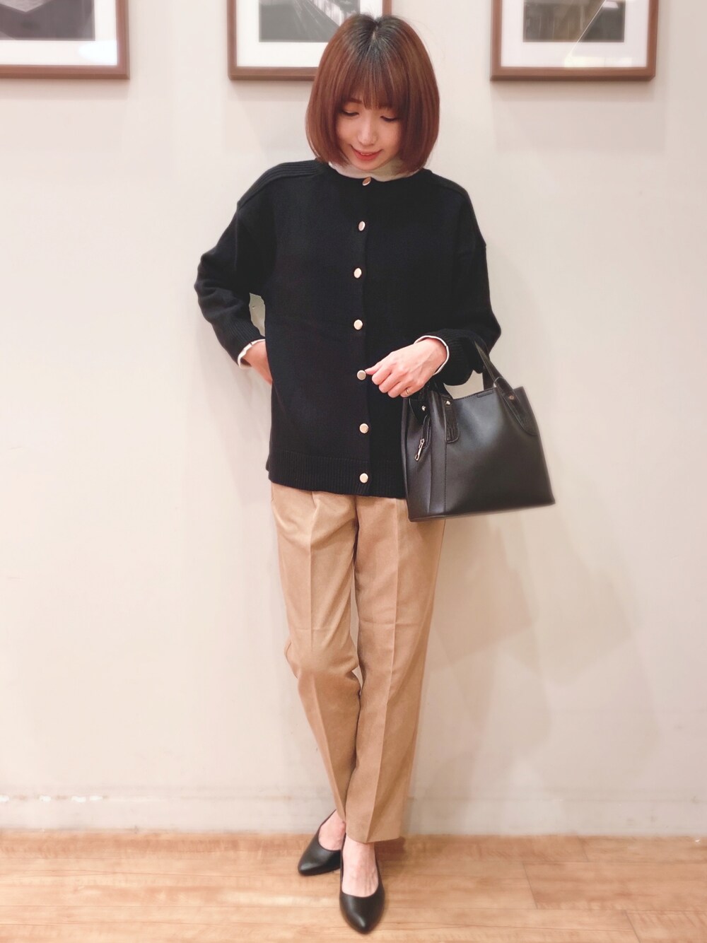 ブラック系のニット/セーター、ブラック系のトートバッグ、ベージュ系のその他パンツを着用したレディースの秋コーディネートの1枚目の写真