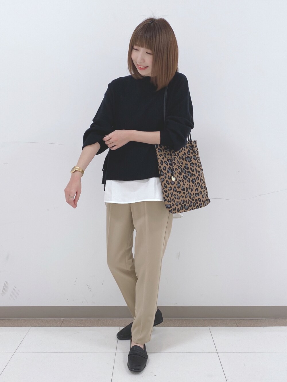 ブラック系のニット/セーター、ベージュ系のその他パンツ、ブラック系のスニーカーを着用したレディースの冬コーディネートの1枚目の写真