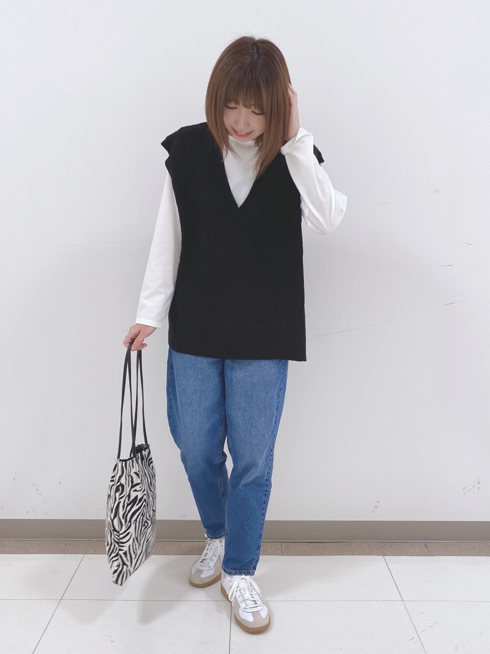 ブラック系のその他トップス、ブルー系のデニムパンツ、ブラック系のトートバッグを着用したレディースの冬コーディネートの1枚目の写真