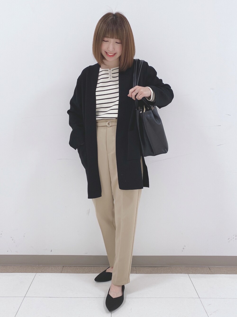 ホワイト系のニット/セーター、ベージュ系のその他パンツ、ブラック系のパンプスを着用したレディースの冬コーディネートの1枚目の写真