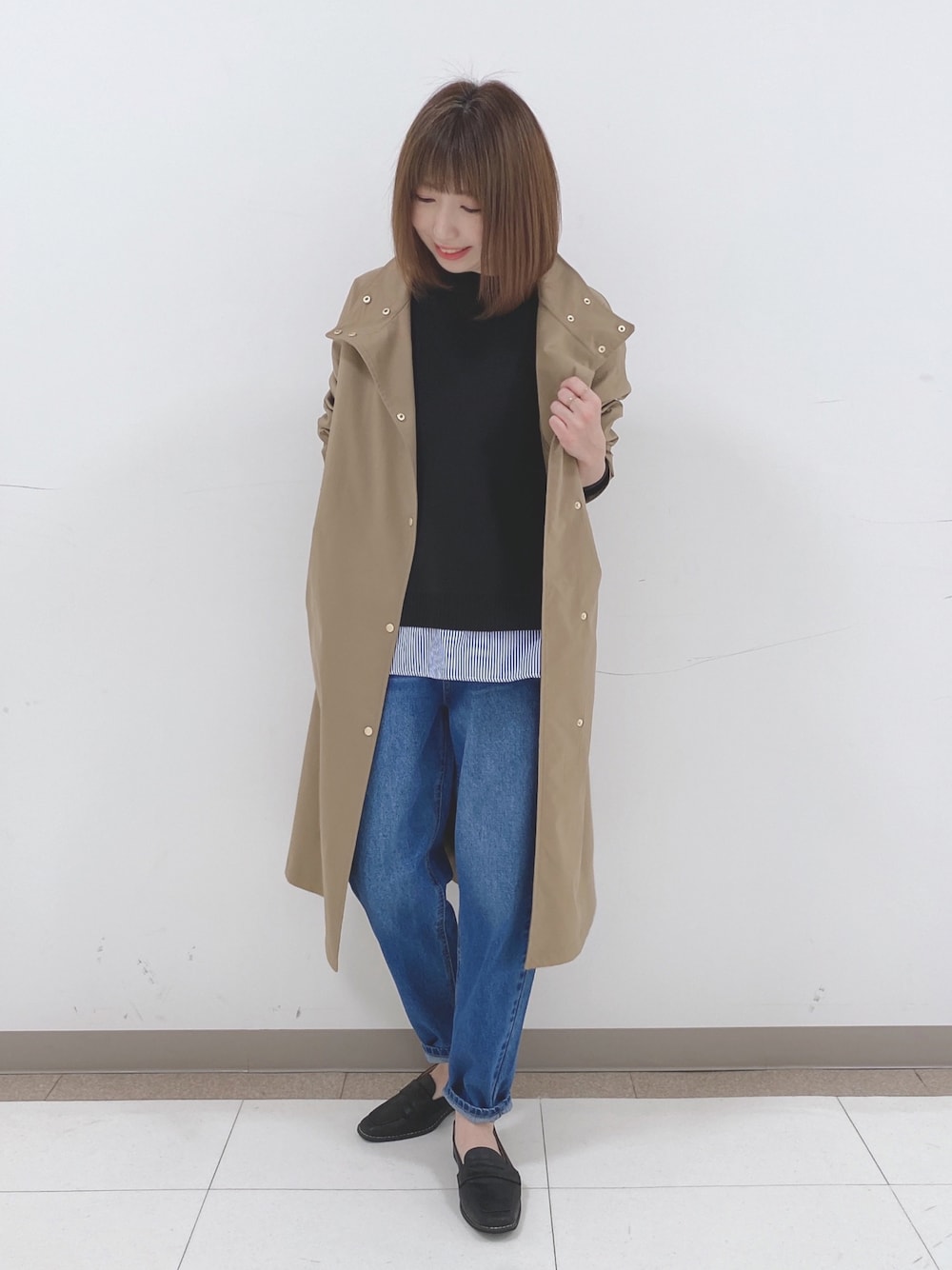 ブラック系のニット/セーター、ベージュ系のその他アウター、ブルー系のデニムパンツを着用したレディースの冬コーディネートの1枚目の写真