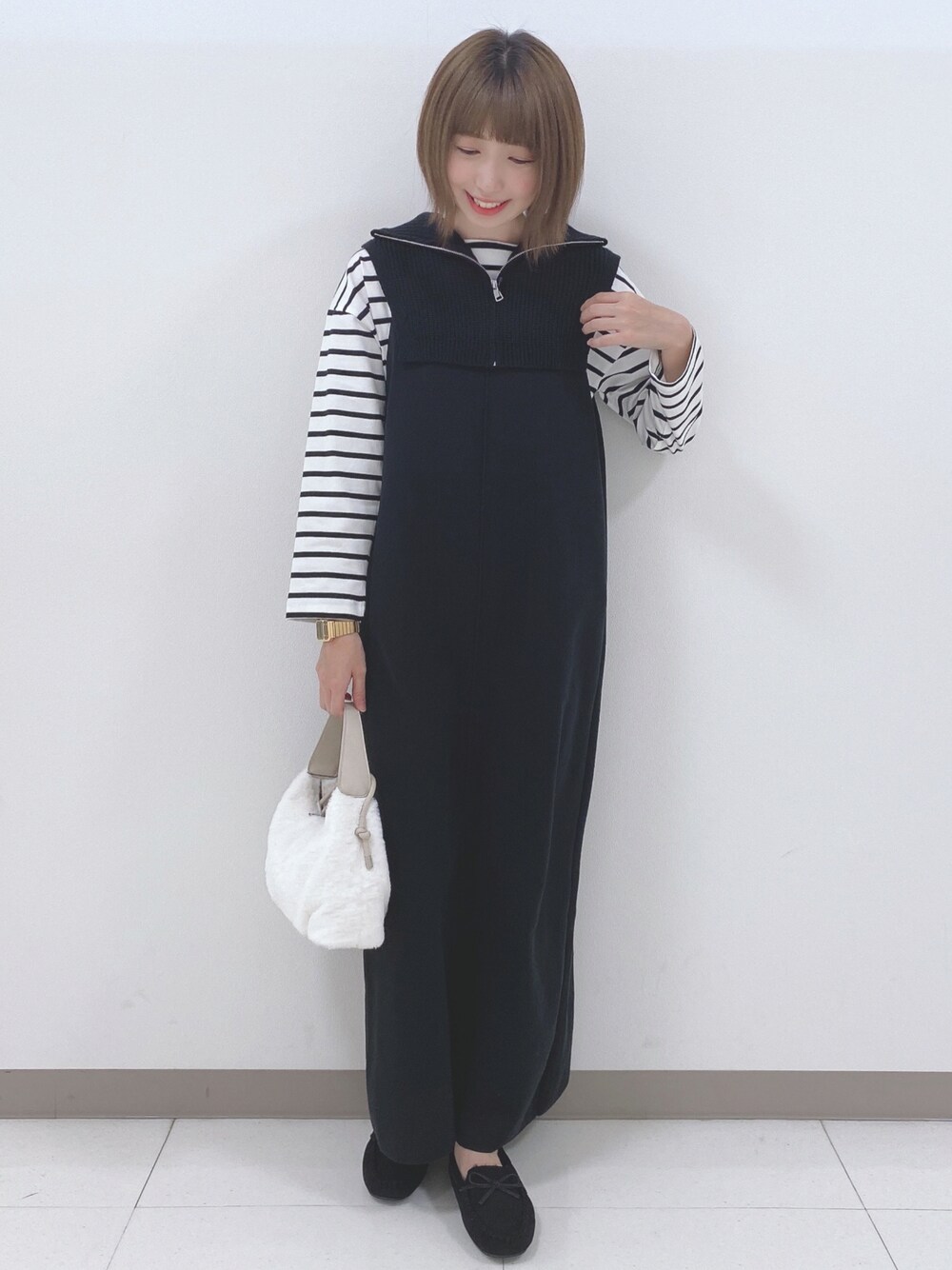 ブラック系のワンピース、ホワイト系のTシャツ/カットソー、ホワイト系のショルダーバッグを着用したレディースの秋コーディネートの1枚目の写真