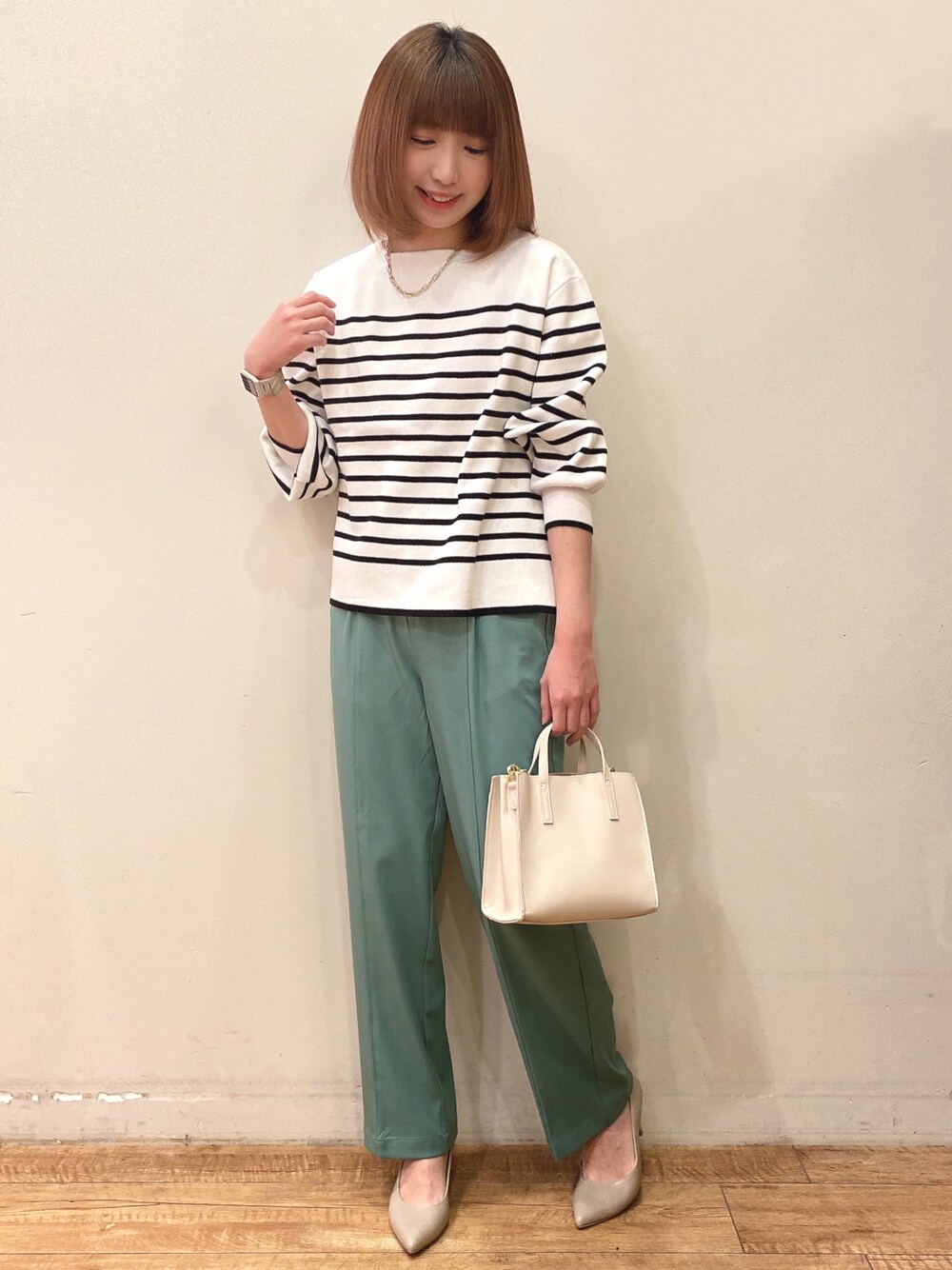 ブラック系のニット/セーター、ホワイト系のショルダーバッグ、グリーン系のその他パンツを着用したレディースの春コーディネートの1枚目の写真