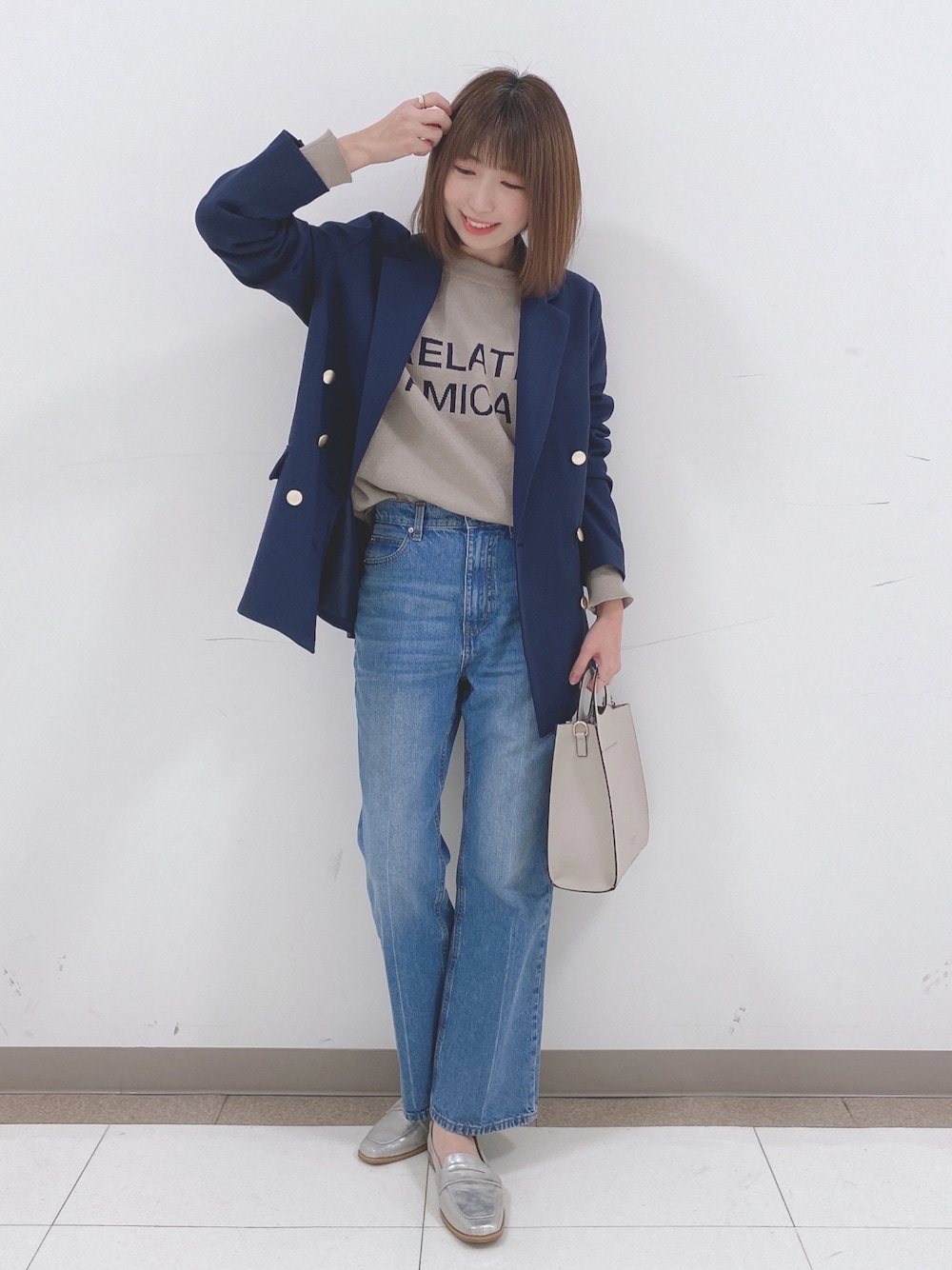 ベージュ系のニット/セーター、ブルー系のテーラードジャケット、ブルー系のデニムパンツを着用したレディースの冬コーディネートの1枚目の写真