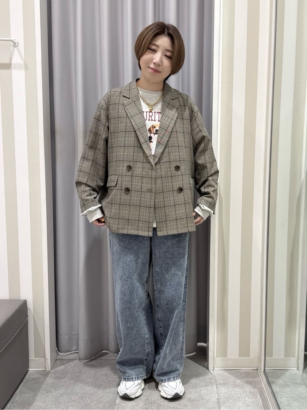 ベージュ系のテーラードジャケット、ホワイト系のスウェット、ブルー系のデニムパンツを着用したレディースの秋コーディネートの1枚目の写真
