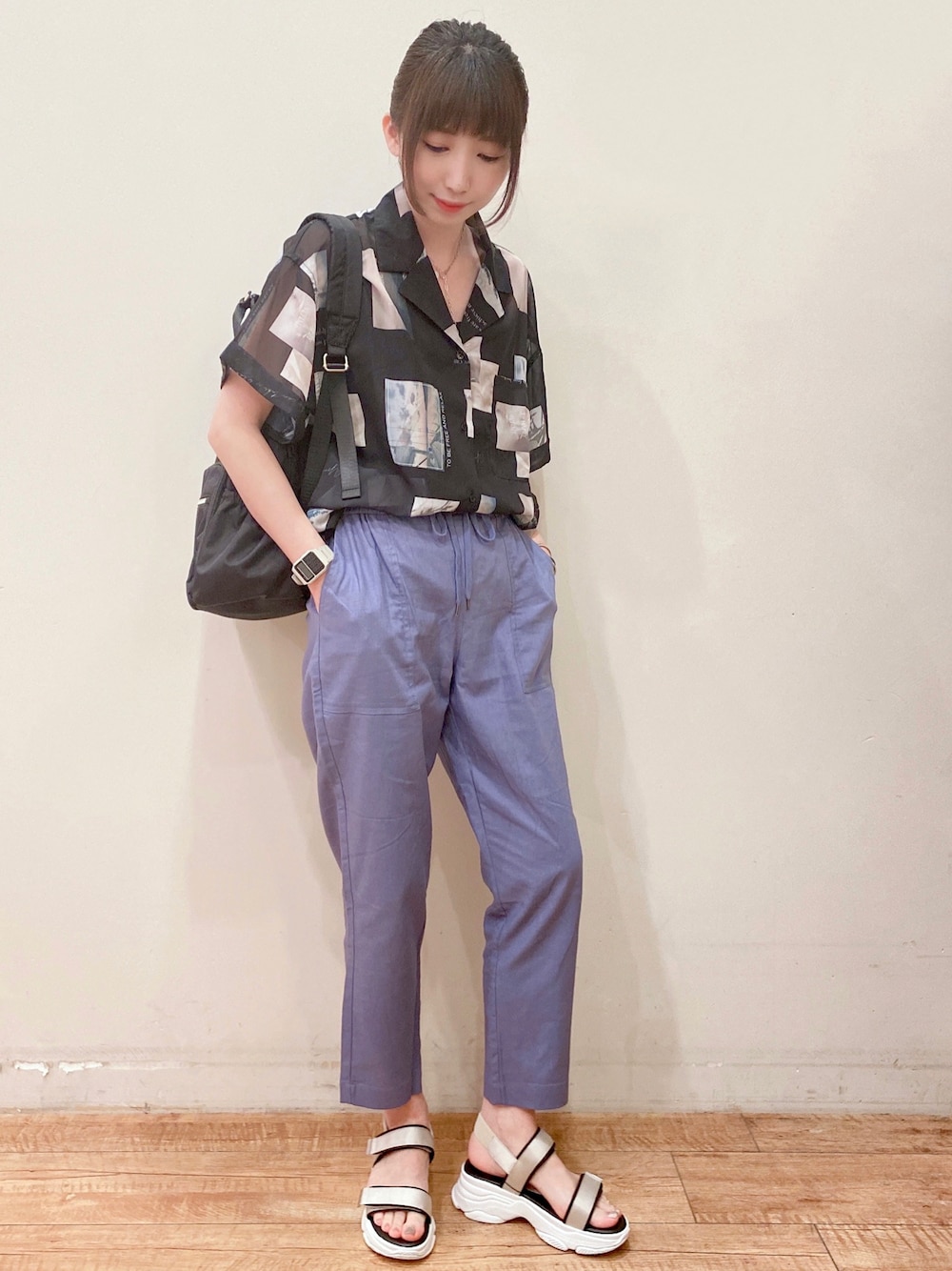 ブルー系のその他パンツ、ベージュ系のサンダル、ブラック系のバックパック/リュックを着用したレディースの春コーディネートの1枚目の写真