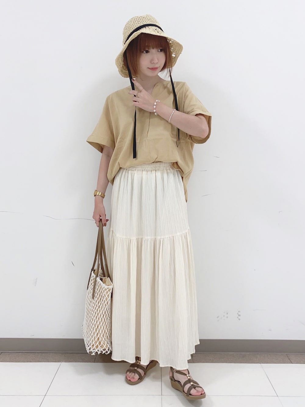 イエロー系のシャツ/ブラウス、ホワイト系のスカート、ホワイト系のトートバッグを着用したレディースの夏コーディネートの1枚目の写真