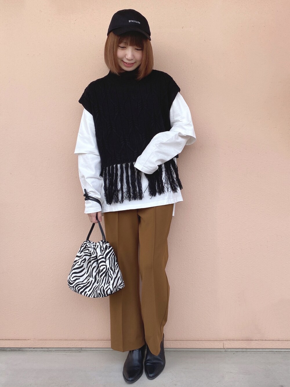 ブラック系のベスト、ホワイト系のTシャツ/カットソー、イエロー系のその他パンツを着用したレディースの冬コーディネートの1枚目の写真