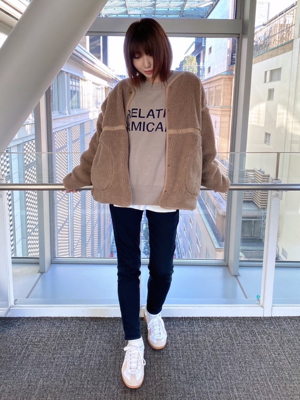 ベージュ系のノーカラージャケット、ベージュ系のニット/セーター、ホワイト系のTシャツ/カットソーを着用したレディースの冬コーディネートの1枚目の写真