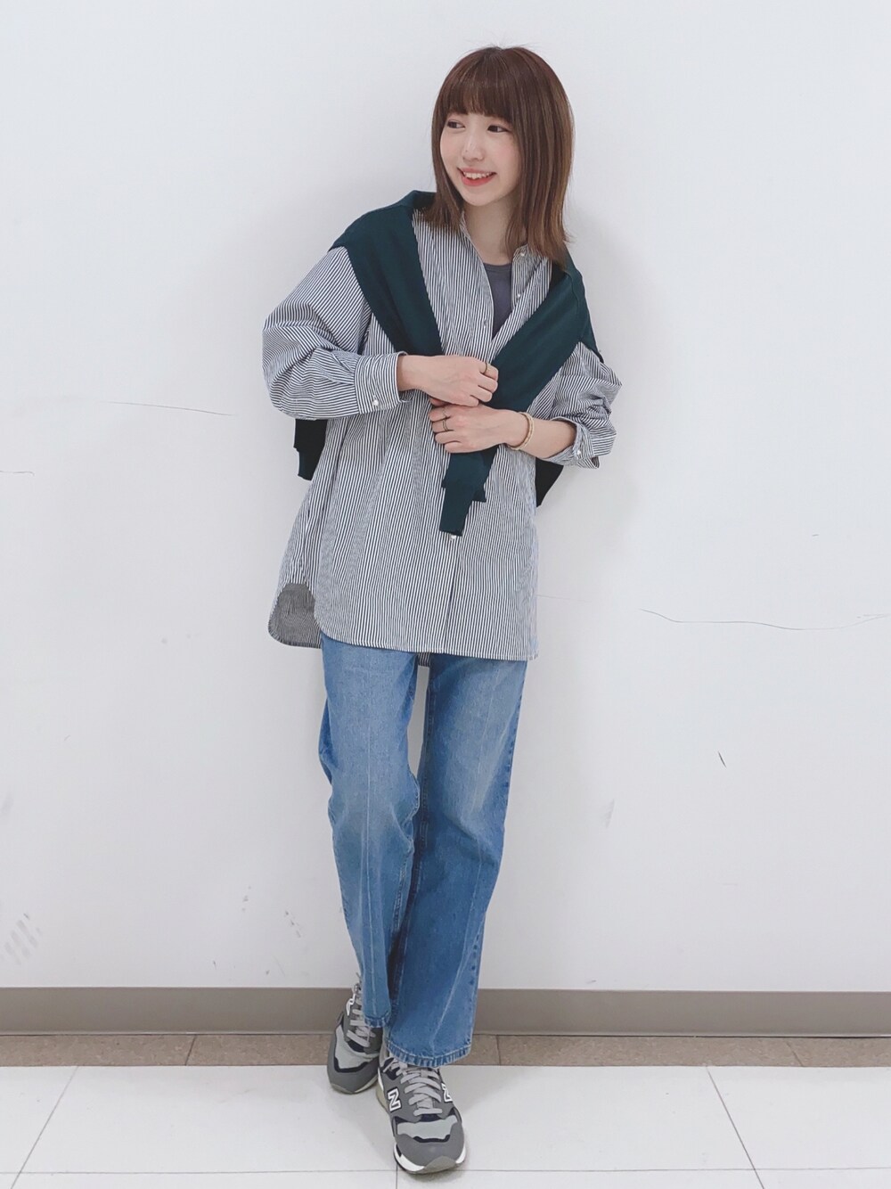 ブルー系のシャツ/ブラウス、ブルー系のデニムパンツ、グリーン系のカーディガン/ボレロを着用したレディースの春コーディネートの1枚目の写真