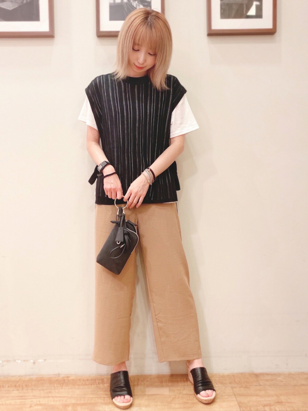 ブラック系のその他トップス、ベージュ系のその他パンツ、ブラック系のサンダルを着用したレディースの夏コーディネートの1枚目の写真