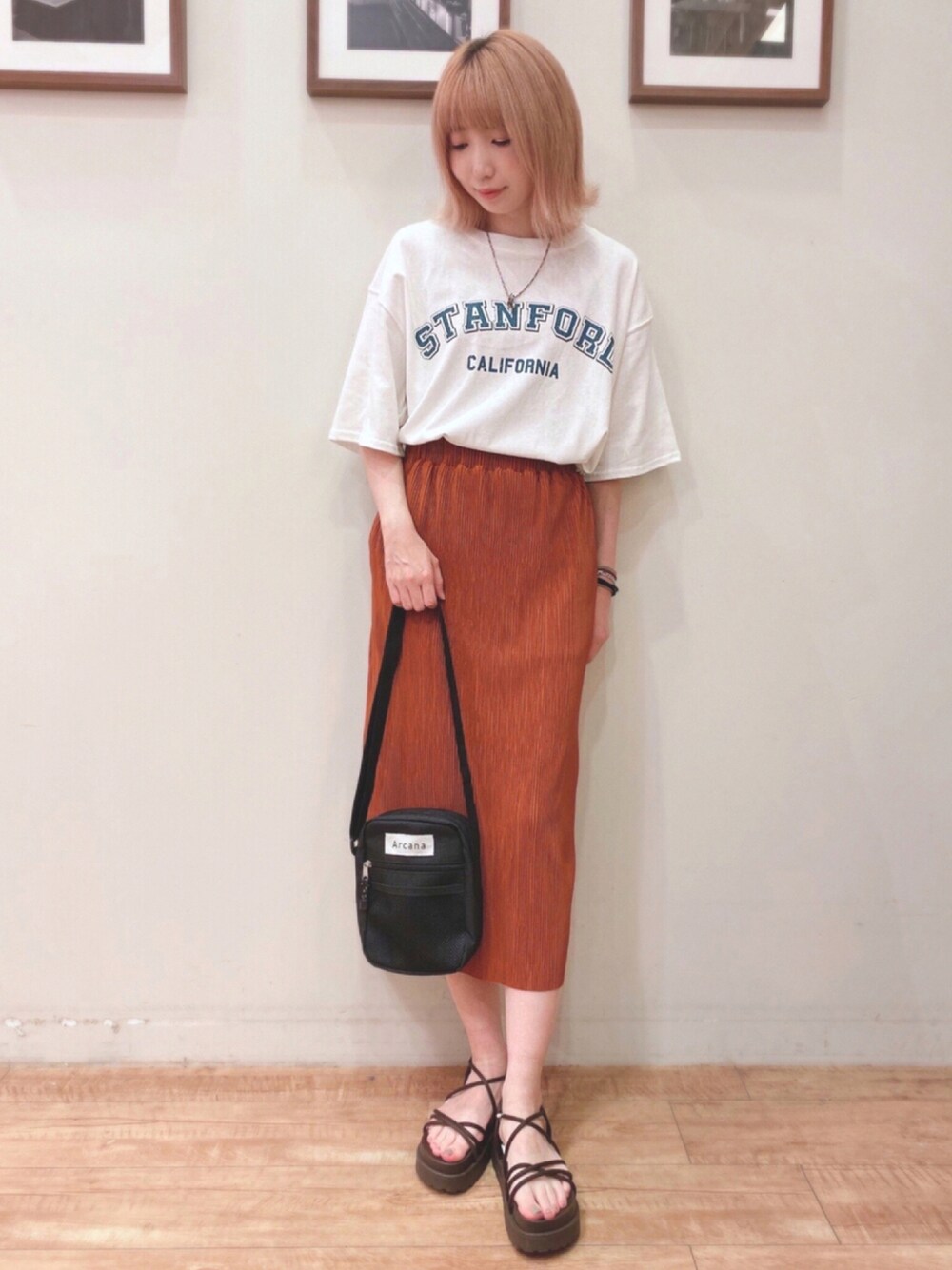 ホワイト系のワンピース、オレンジ系のスカート、ブラック系のショルダーバッグを着用したレディースの夏コーディネートの1枚目の写真