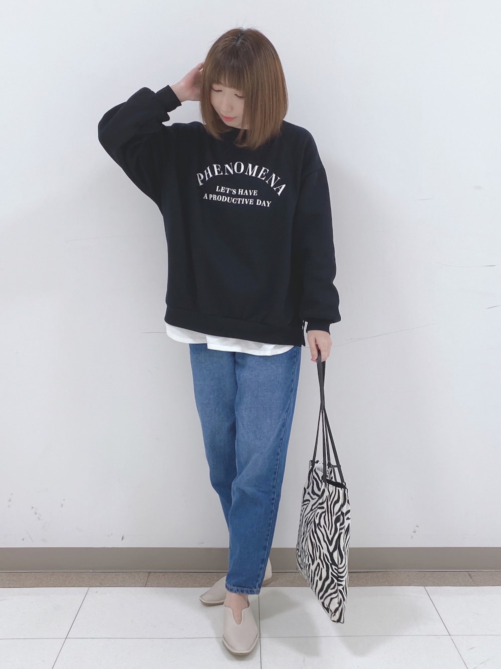 ブラック系のスウェット、ホワイト系のTシャツ/カットソー、ブルー系のデニムパンツを着用したレディースの冬コーディネートの1枚目の写真