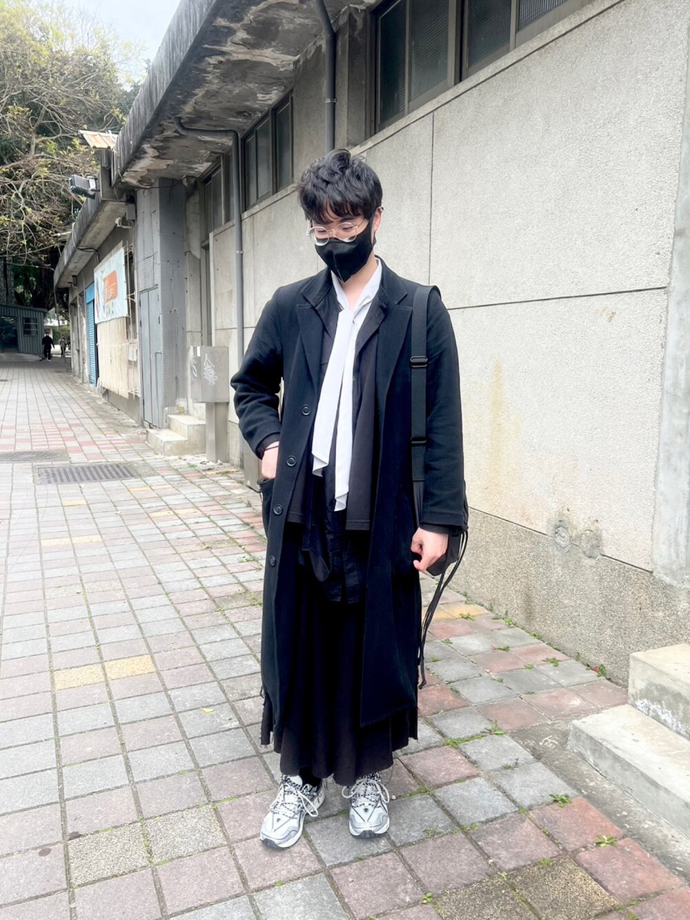 シルバー系のスニーカー、ブラック系のその他パンツ、ブラック系のピーコートを着用したメンズの冬コーディネートの1枚目の写真