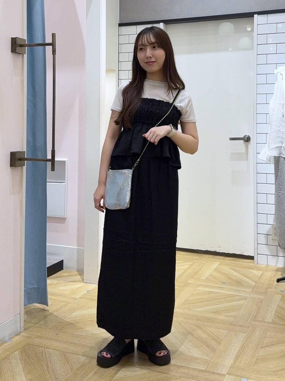 シルバー系のショルダーバッグ、ブラック系のスカート、ホワイト系のTシャツ/カットソーを着用したレディースの秋コーディネートの1枚目の写真