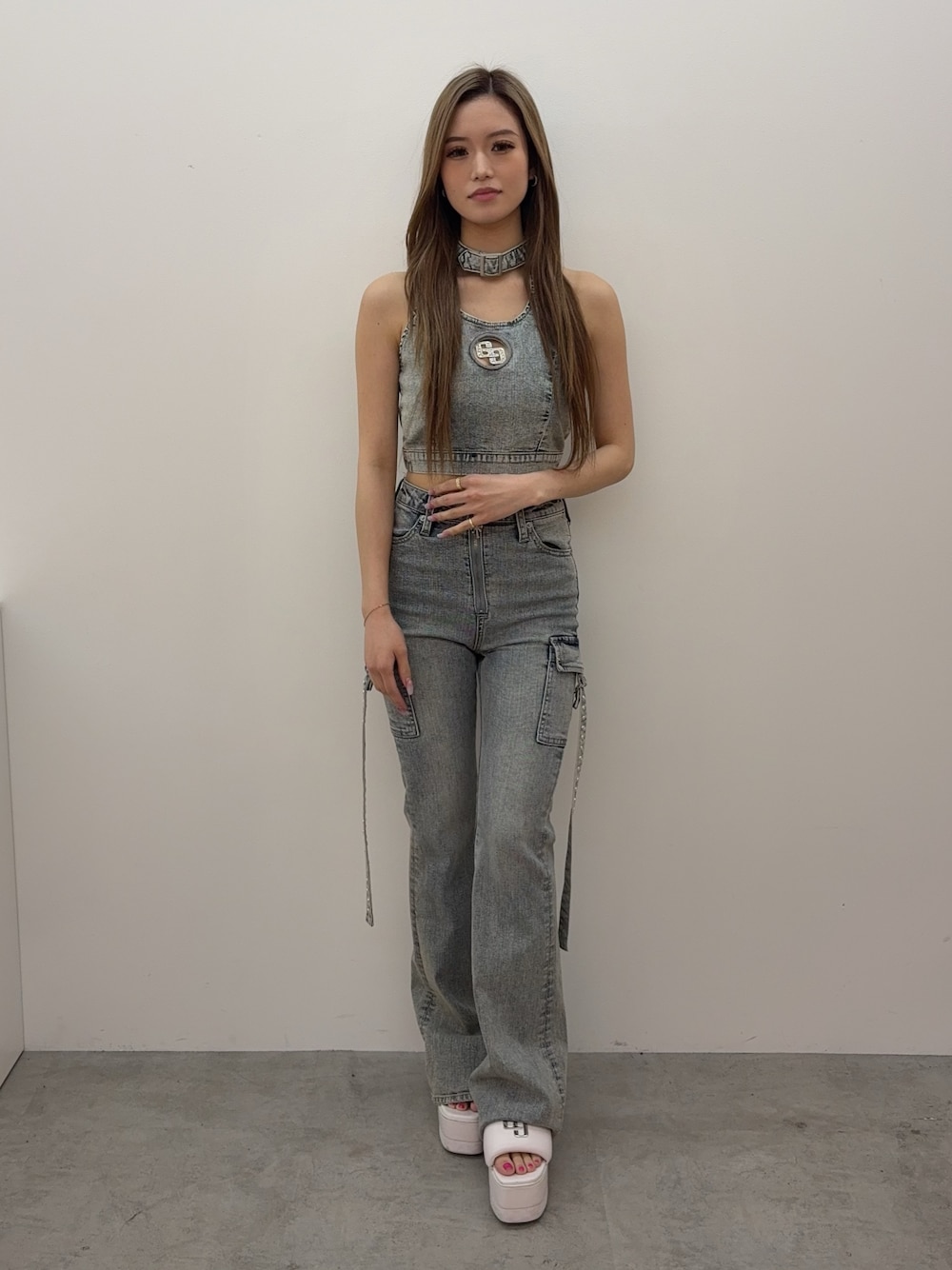 ブルー系のタンクトップ、ブルー系のデニムパンツ、ホワイト系のサンダルを着用したレディースの春コーディネートの1枚目の写真