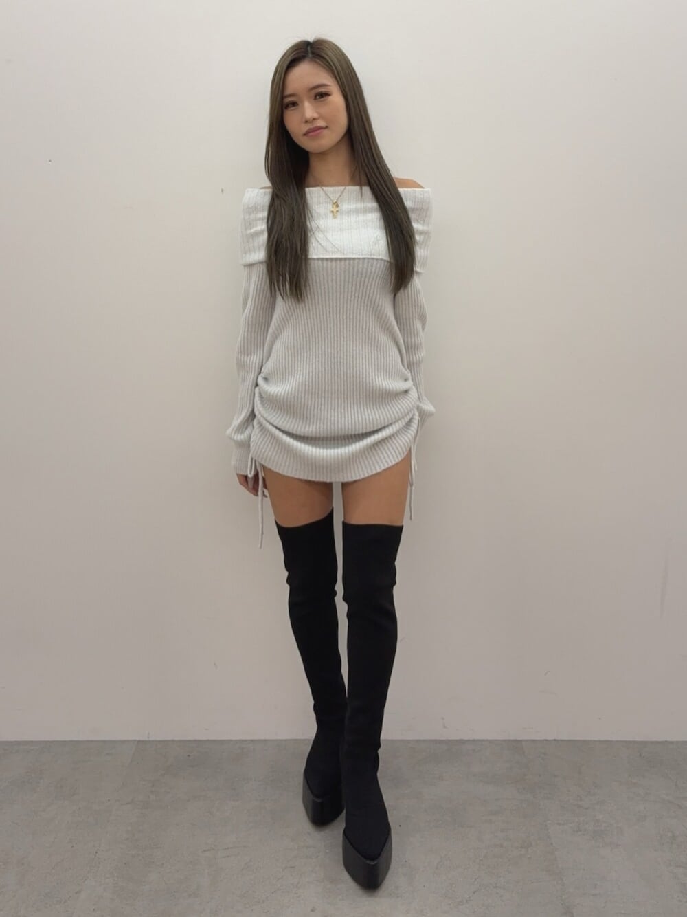 ホワイト系のチュニック、ブラック系のブーツを着用したレディースの秋コーディネートの1枚目の写真