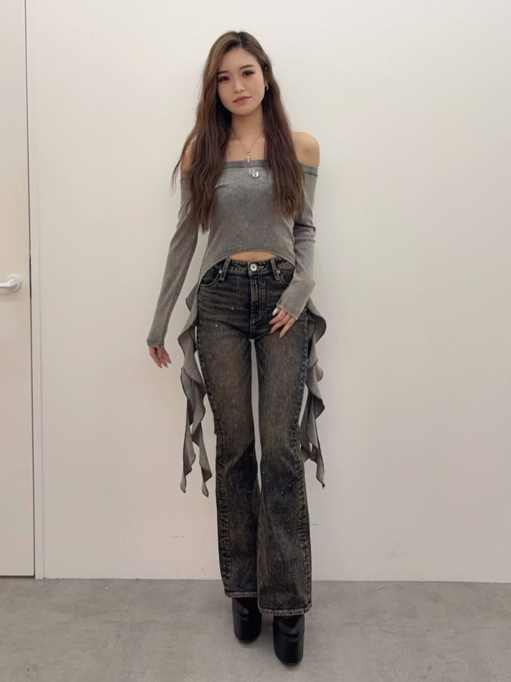 ブラック系のブーツ、ブルー系のデニムパンツ、グレー系のTシャツ/カットソーを着用したレディースの春コーディネートの1枚目の写真