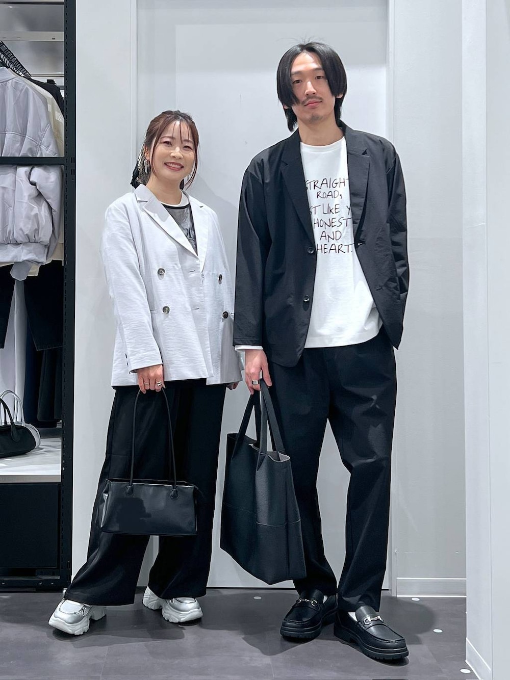 ブラック系のテーラードジャケット、ブラック系のトートバッグ、ホワイト系のTシャツ/カットソーを着用したレディースの春コーディネートの1枚目の写真