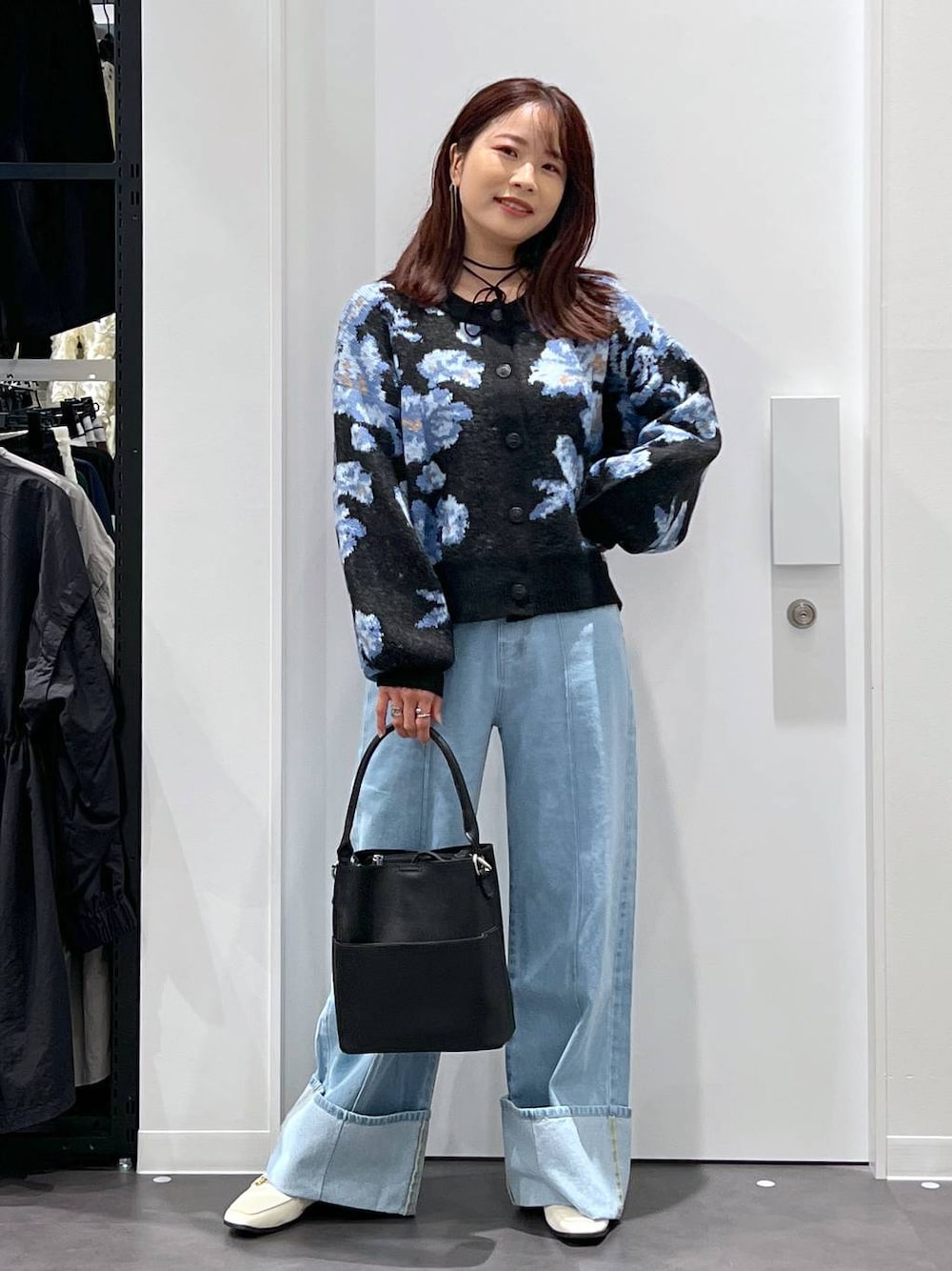 ブルー系のデニムパンツ、ブラック系のショルダーバッグ、ベージュ系のローファーを着用したレディースの秋コーディネートの1枚目の写真