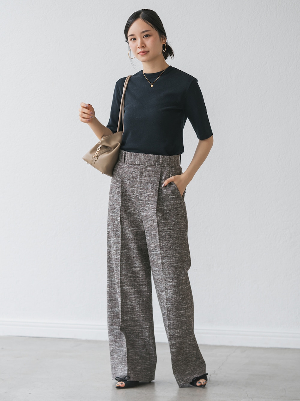 ブラック系のスラックス、ブルー系のニット/セーターを着用したレディースの秋コーディネートの1枚目の写真