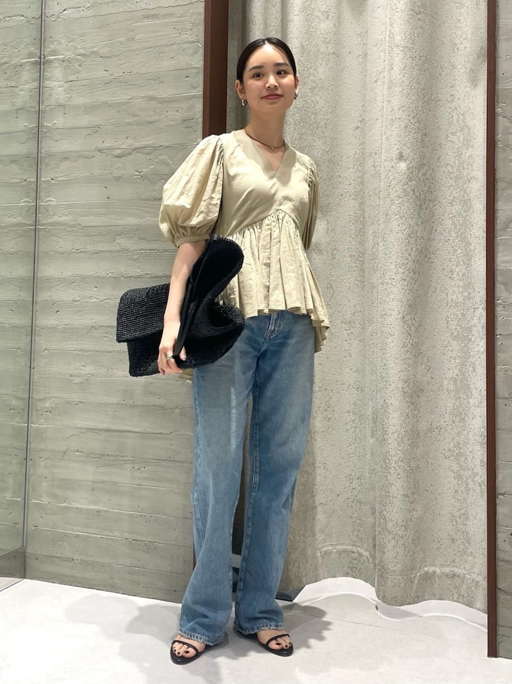 ベージュ系のシャツ/ブラウス、ブルー系のデニムパンツ、ブラック系のサンダルを着用したレディースの春コーディネートの1枚目の写真