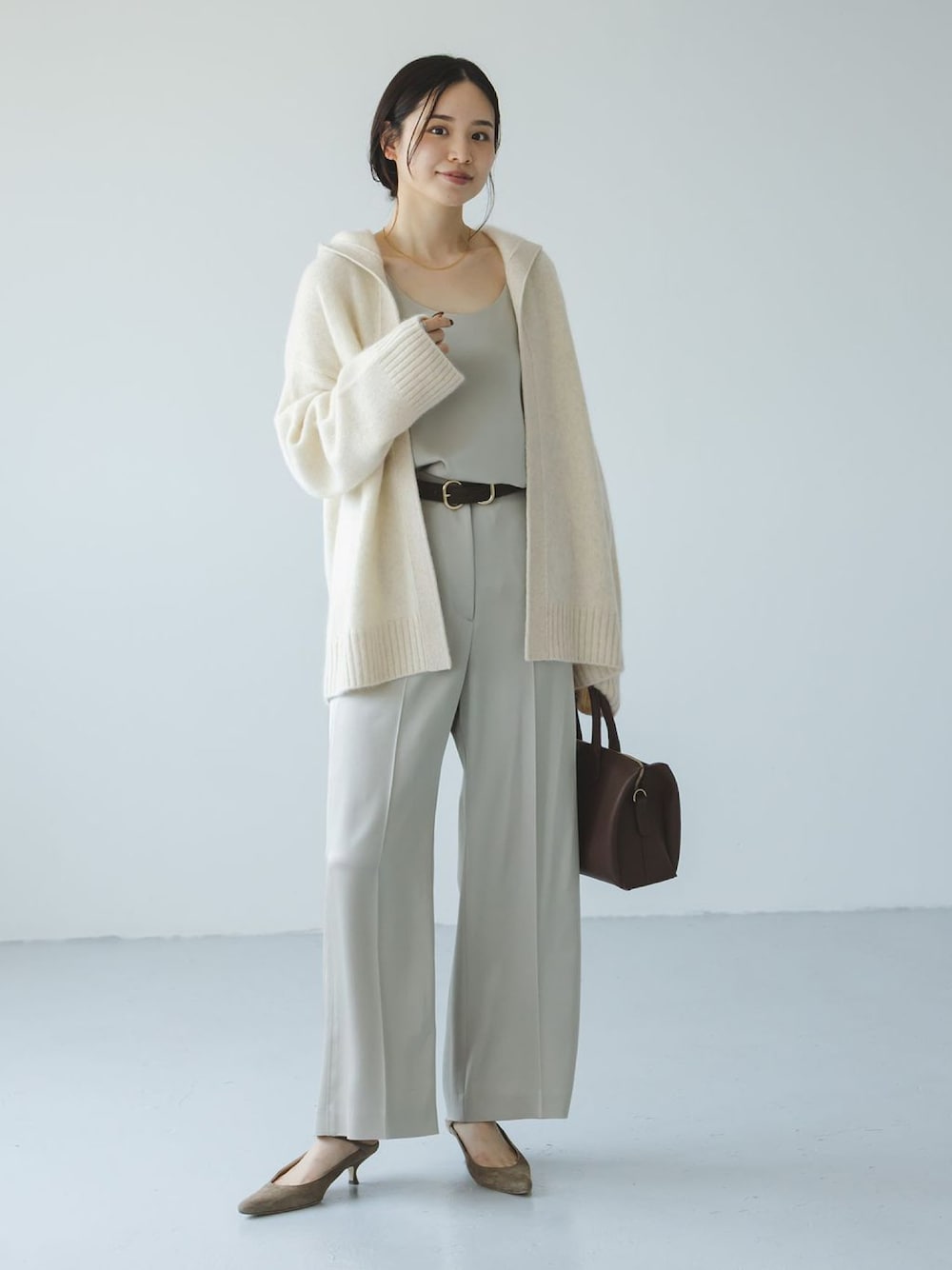 ホワイト系のカーディガン/ボレロ、ベージュ系のスラックス、ベージュ系のシャツ/ブラウスを着用したレディースの秋コーディネートの1枚目の写真