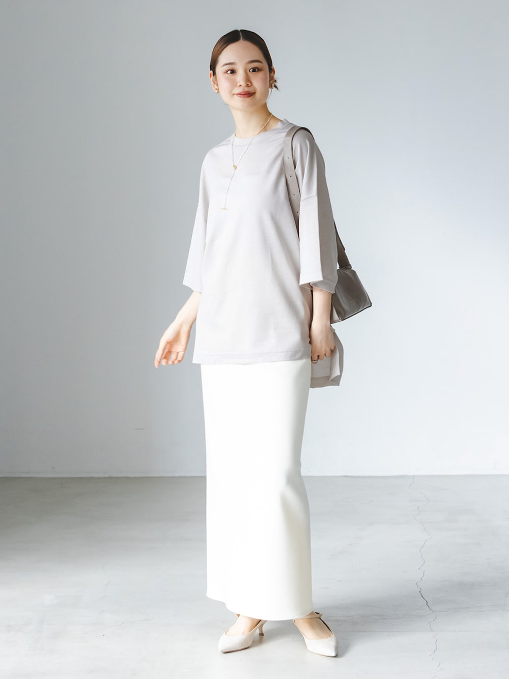 ベージュ系のTシャツ/カットソー、ホワイト系のスカート、グレー系のショルダーバッグを着用したレディースの春コーディネートの1枚目の写真
