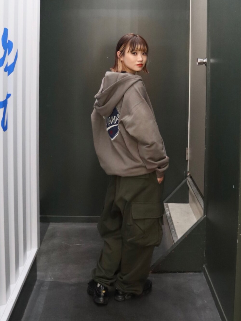 グレー系のパーカー、グリーン系のスウェットパンツ、ブラック系のTシャツ/カットソーを着用したレディースの秋コーディネートの1枚目の写真