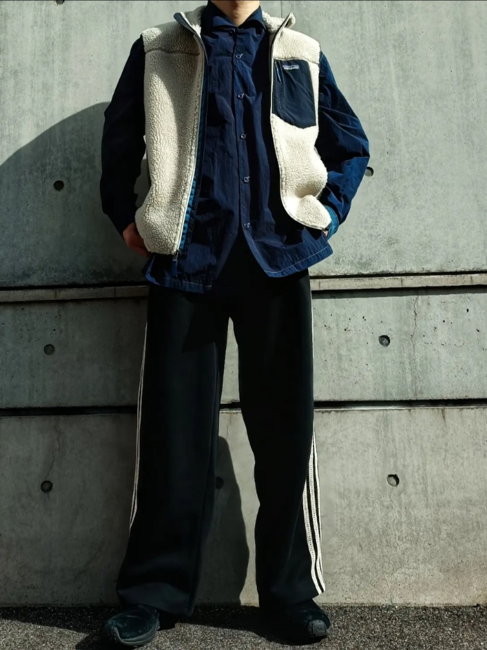 ブルー系のシャツ/ブラウス、ホワイト系のベスト、ブラック系のパンツを着用したメンズの秋コーディネートの1枚目の写真