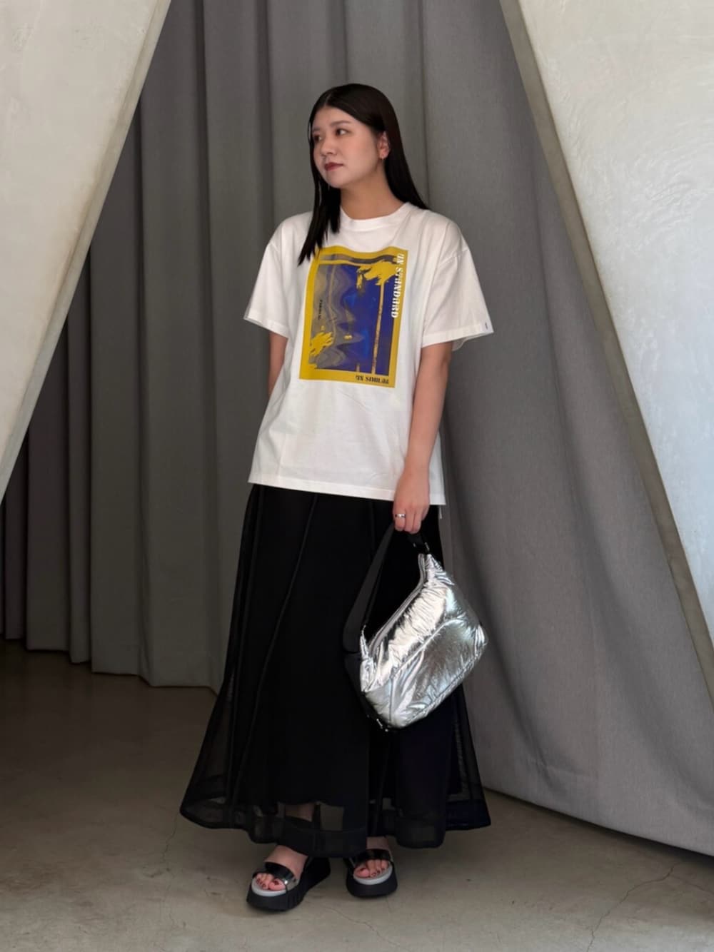 シルバー系のショルダーバッグ、ホワイト系のTシャツ/カットソー、ブラック系のスカートを着用したレディースの夏コーディネートの1枚目の写真
