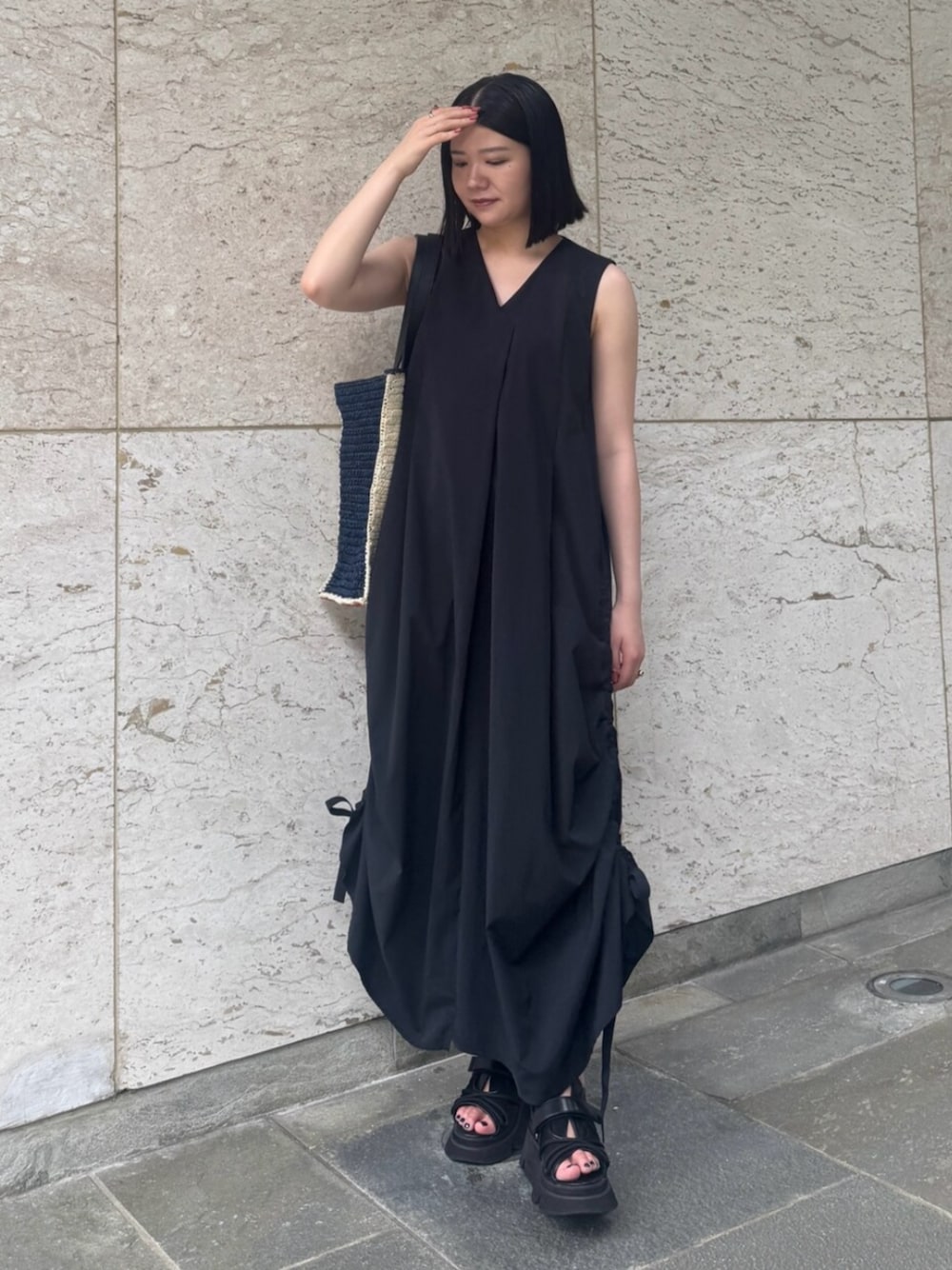 ブラック系のサンダル、ブラック系のワンピース、ブルー系のトートバッグを着用したレディースの夏コーディネートの1枚目の写真