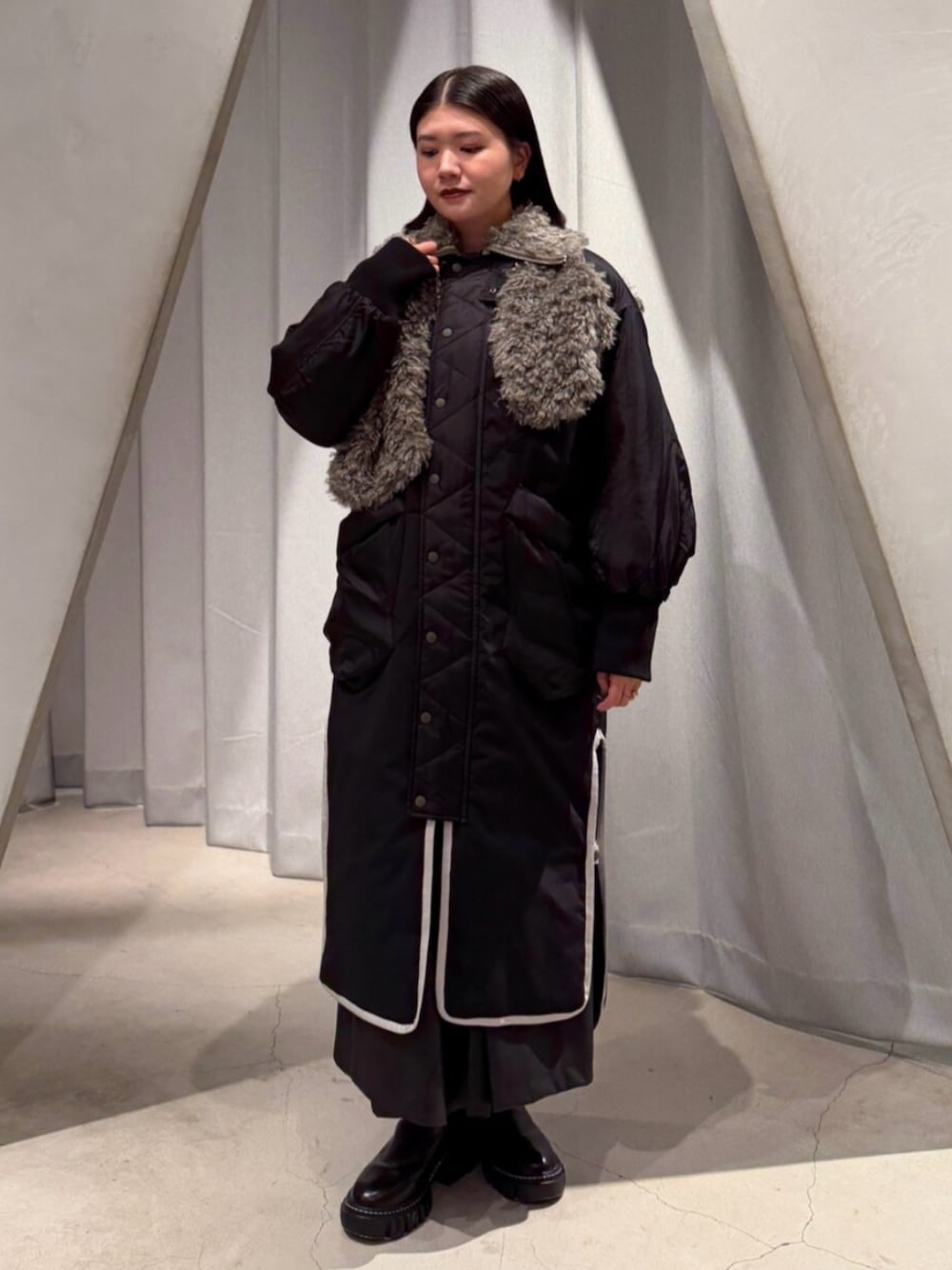 ブラック系のブーツ、ブラック系のその他アウター、ブラック系のその他パンツを着用したレディースの秋コーディネートの1枚目の写真