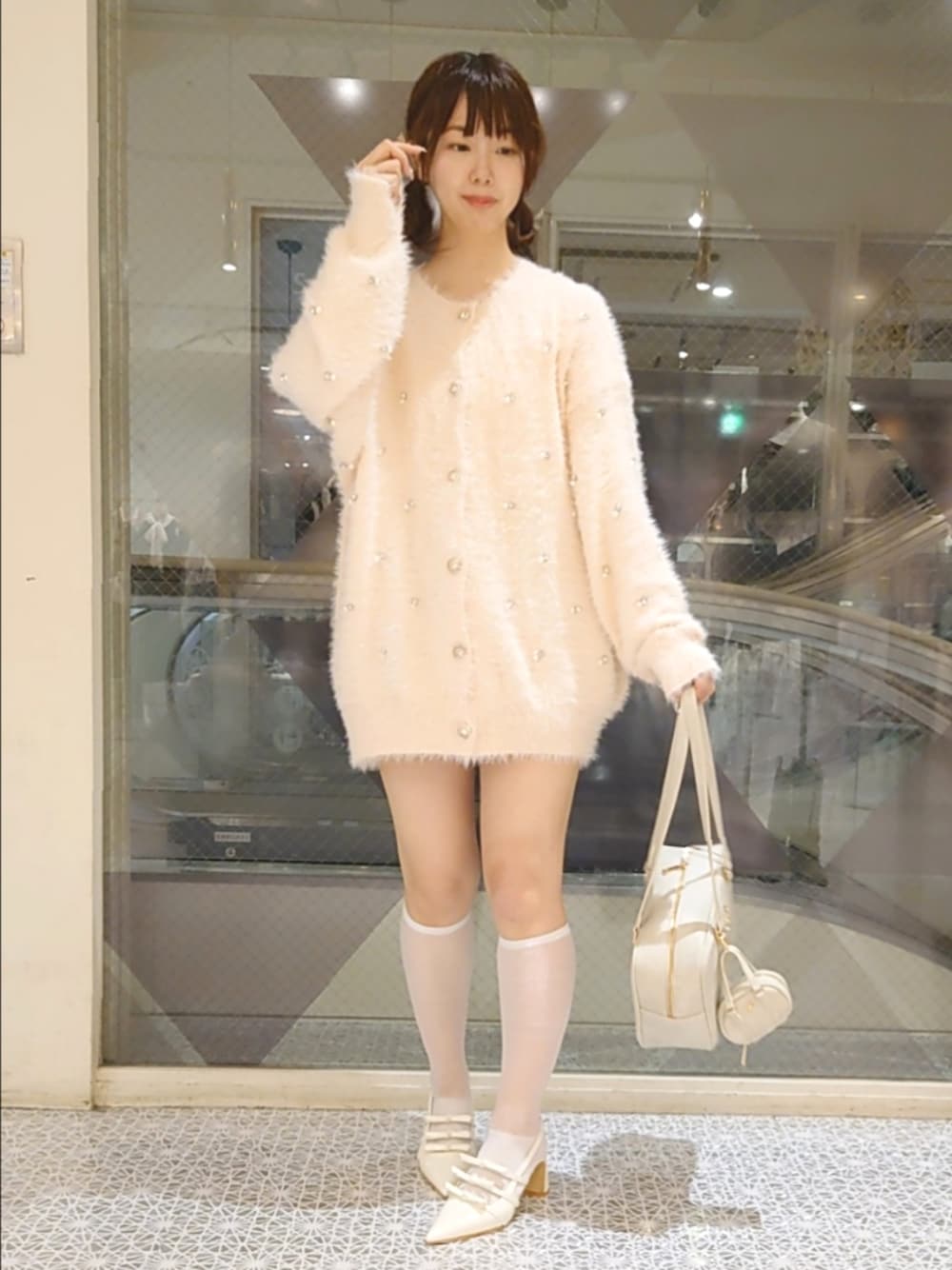 ピンク系のカーディガン/ボレロ、ホワイト系のボストンバッグ、ホワイト系のパンプスを着用したレディースの夏コーディネートの1枚目の写真