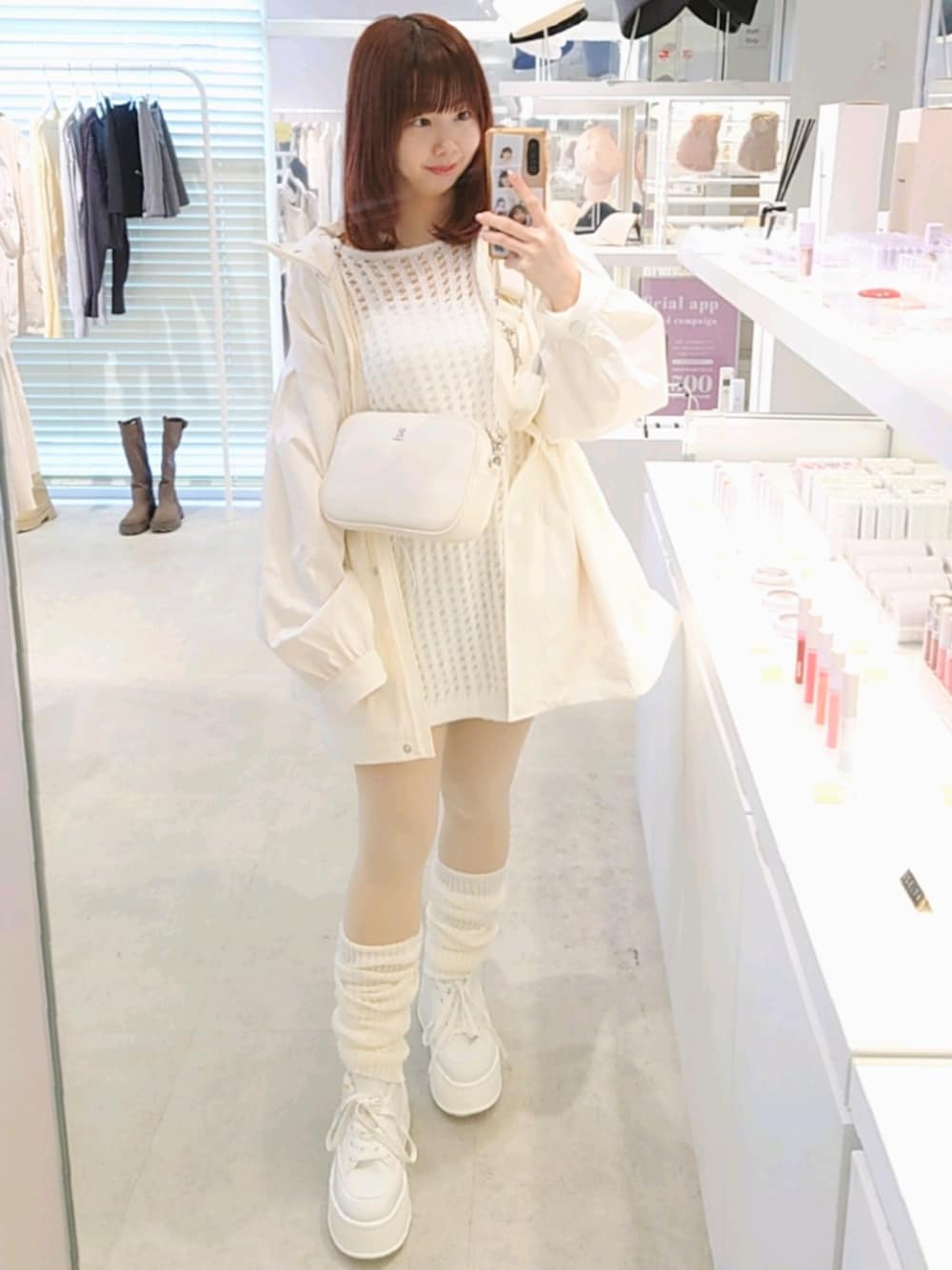 ホワイト系のマウンテンパーカー、ホワイト系のボディバッグ/ウエストポーチ、ホワイト系のスニーカーを着用したレディースの春コーディネートの1枚目の写真