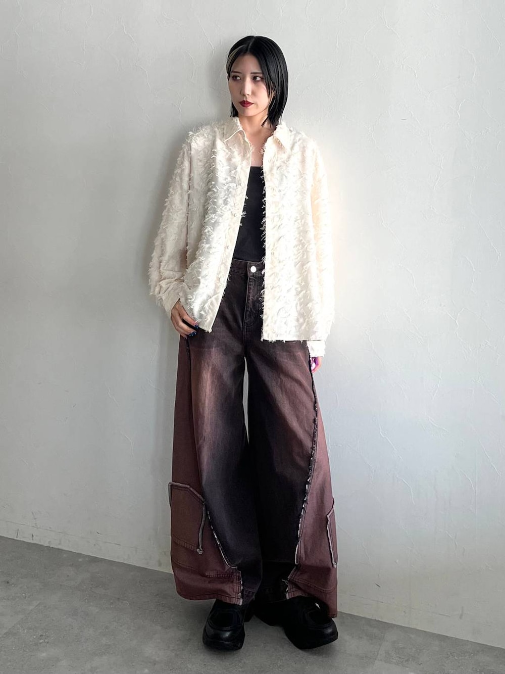 ブラック系のスニーカー、ホワイト系のシャツ/ブラウスを着用したレディースの秋コーディネートの1枚目の写真