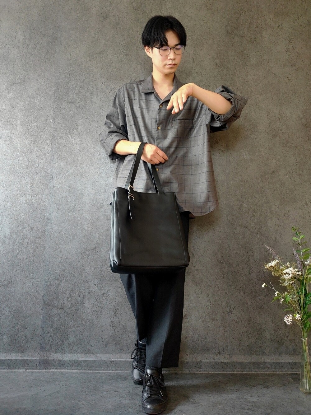 ブラック系のトートバッグ、ブラック系のスラックス、ブラック系のスニーカーを着用したメンズの夏コーディネートの1枚目の写真