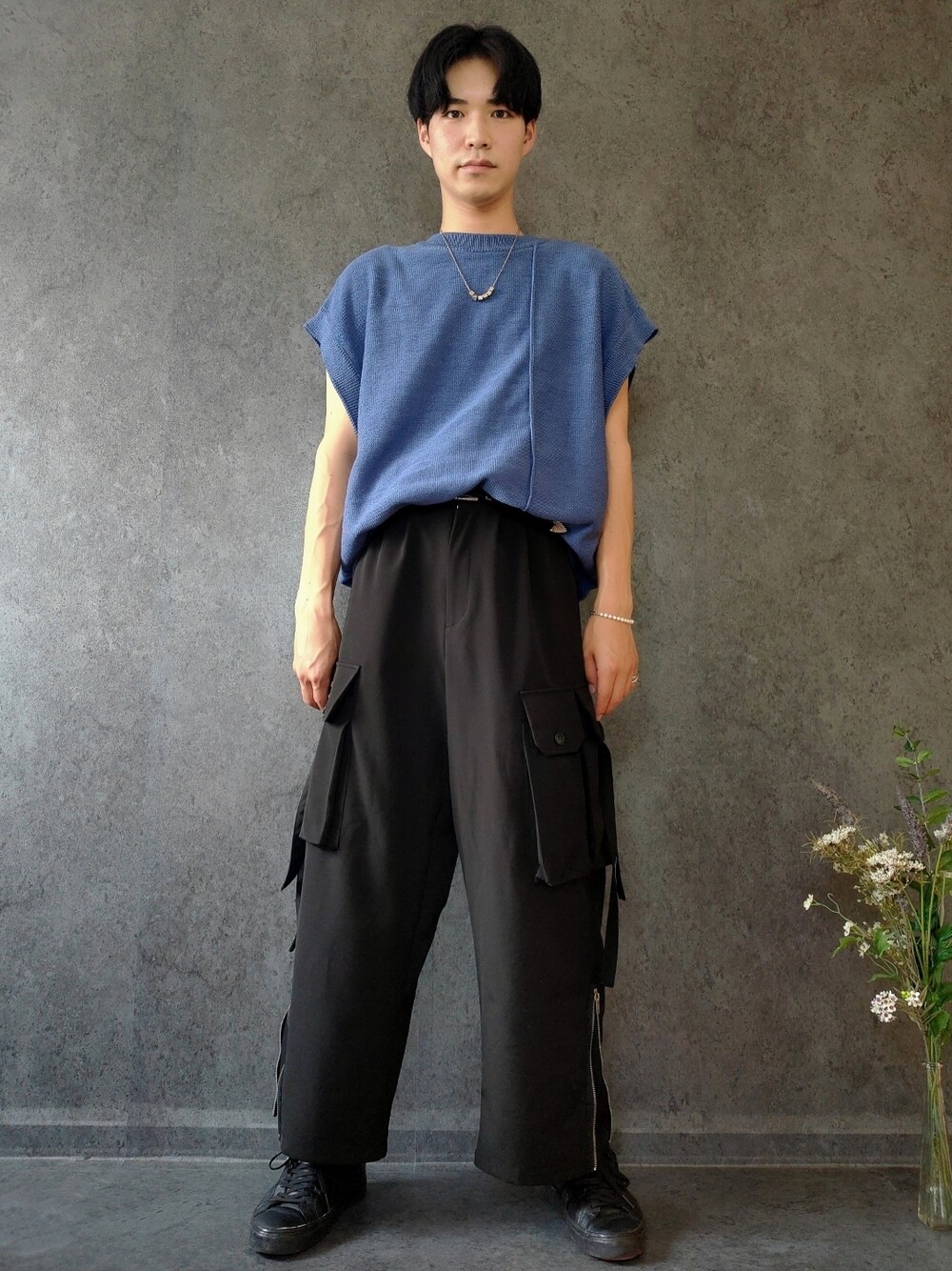 ブルー系のベスト、ブラック系のカーゴパンツ、ブラック系のスニーカーを着用したメンズの夏コーディネートの1枚目の写真