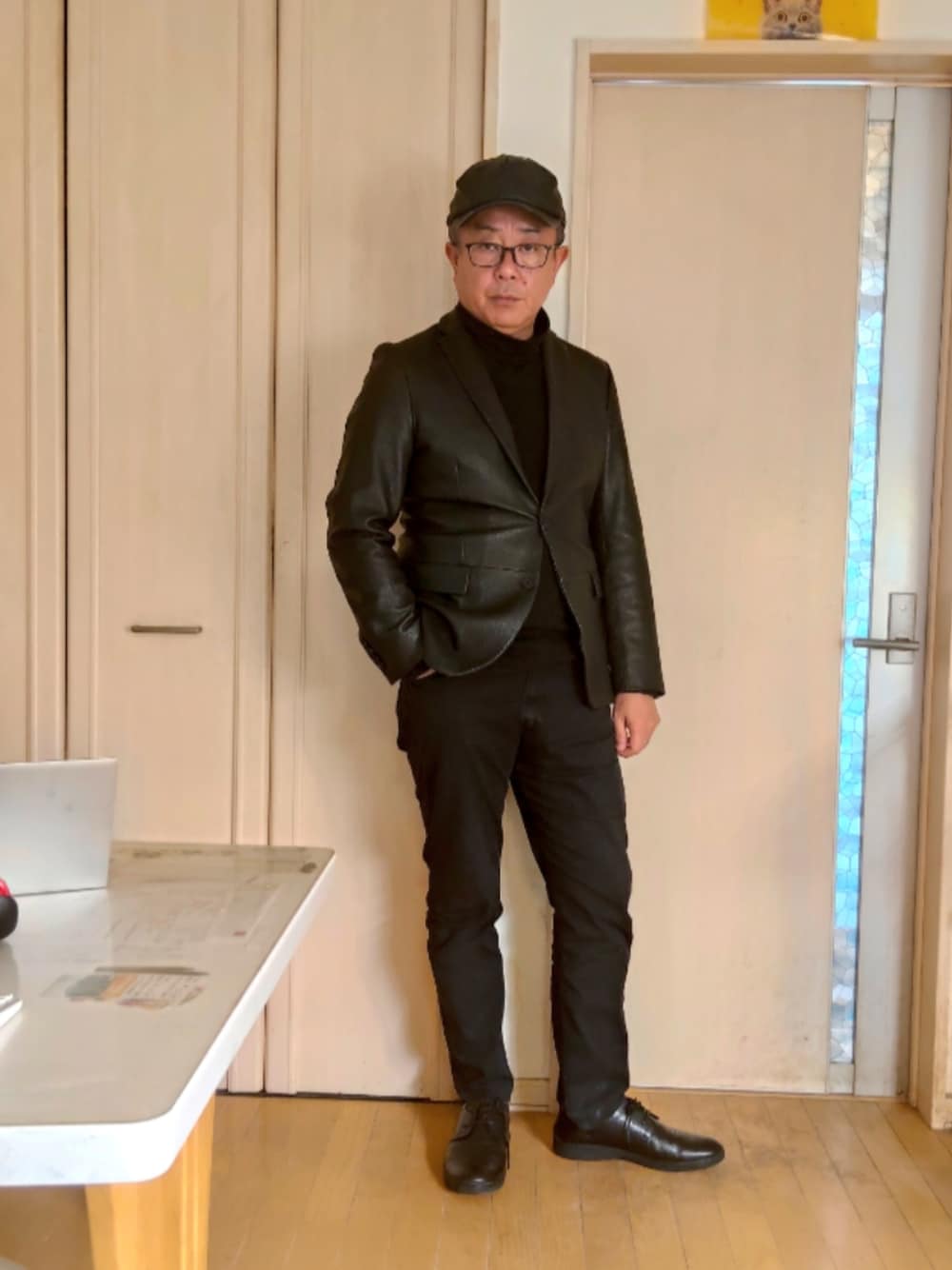 ブラック系のテーラードジャケット、ブラック系のデニムパンツ、ブラック系のスニーカーを着用したメンズの秋コーディネートの1枚目の写真