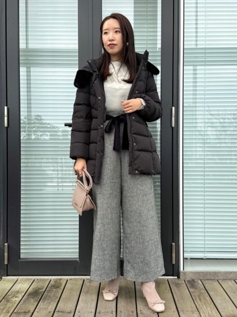 ブラック系のその他パンツ、グレー系のニット/セーター、ブラック系のダウンジャケット/コートを着用したレディースの冬コーディネートの1枚目の写真