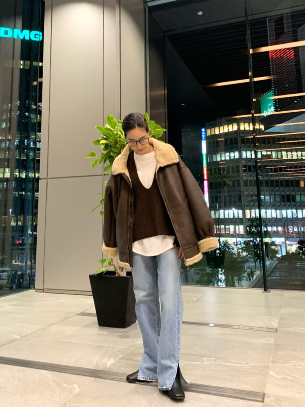 ブラック系のブーツ、ブルー系のデニムパンツ、ホワイト系のTシャツ/カットソーを着用したレディースの秋コーディネートの1枚目の写真