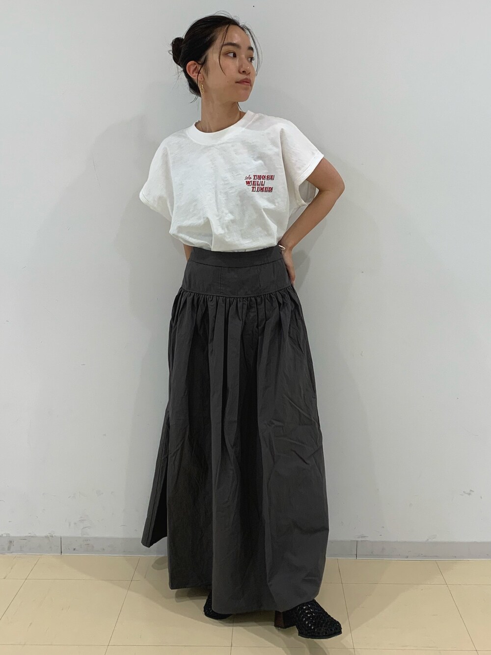 ホワイト系のTシャツ/カットソー、グレー系のスカート、ブラック系のサンダルを着用したレディースの春コーディネートの1枚目の写真