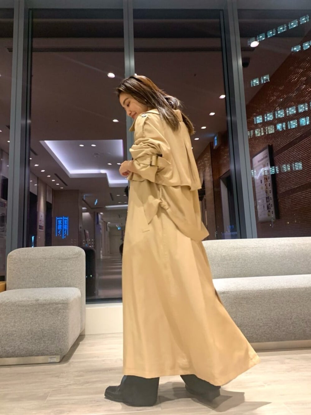 ベージュ系のトレンチコート、グレー系のスラックス、ホワイト系のTシャツ/カットソーを着用したレディースの秋コーディネートの1枚目の写真