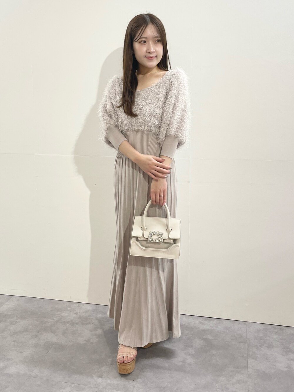 ベージュ系のワンピース、ベージュ系のショルダーバッグ、その他のサンダルを着用したレディースの冬コーディネートの1枚目の写真