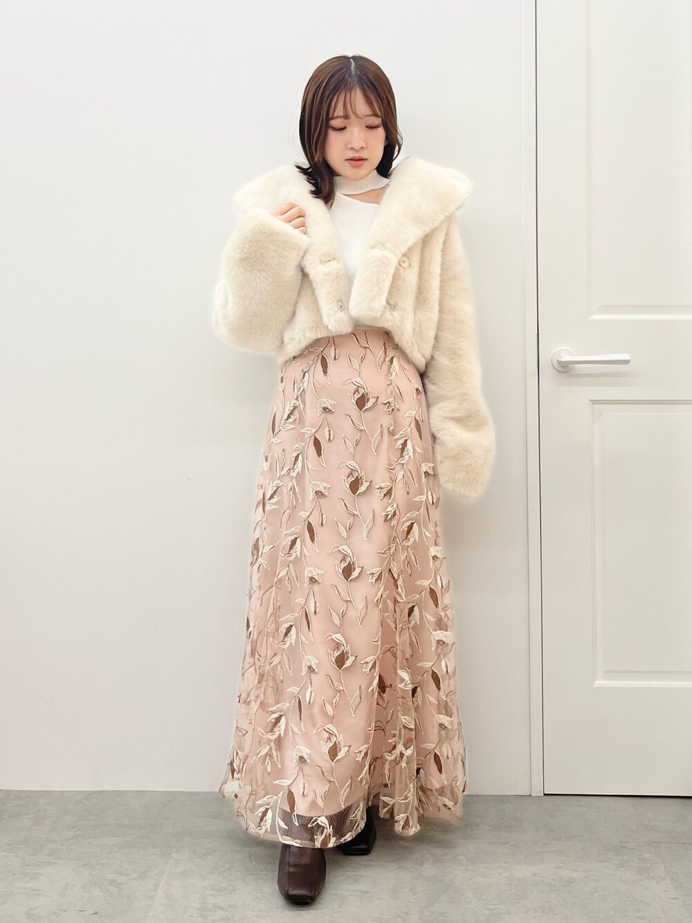 ピンク系のスカート、ホワイト系のニット/セーター、ホワイト系のその他アウターを着用したレディースの秋コーディネートの1枚目の写真