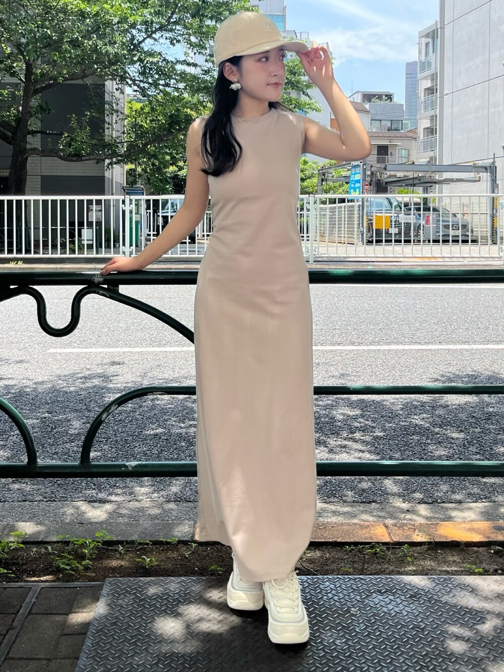 ベージュ系のスニーカー、ベージュ系のワンピース、ベージュ系のキャップを着用したレディースの夏コーディネートの1枚目の写真