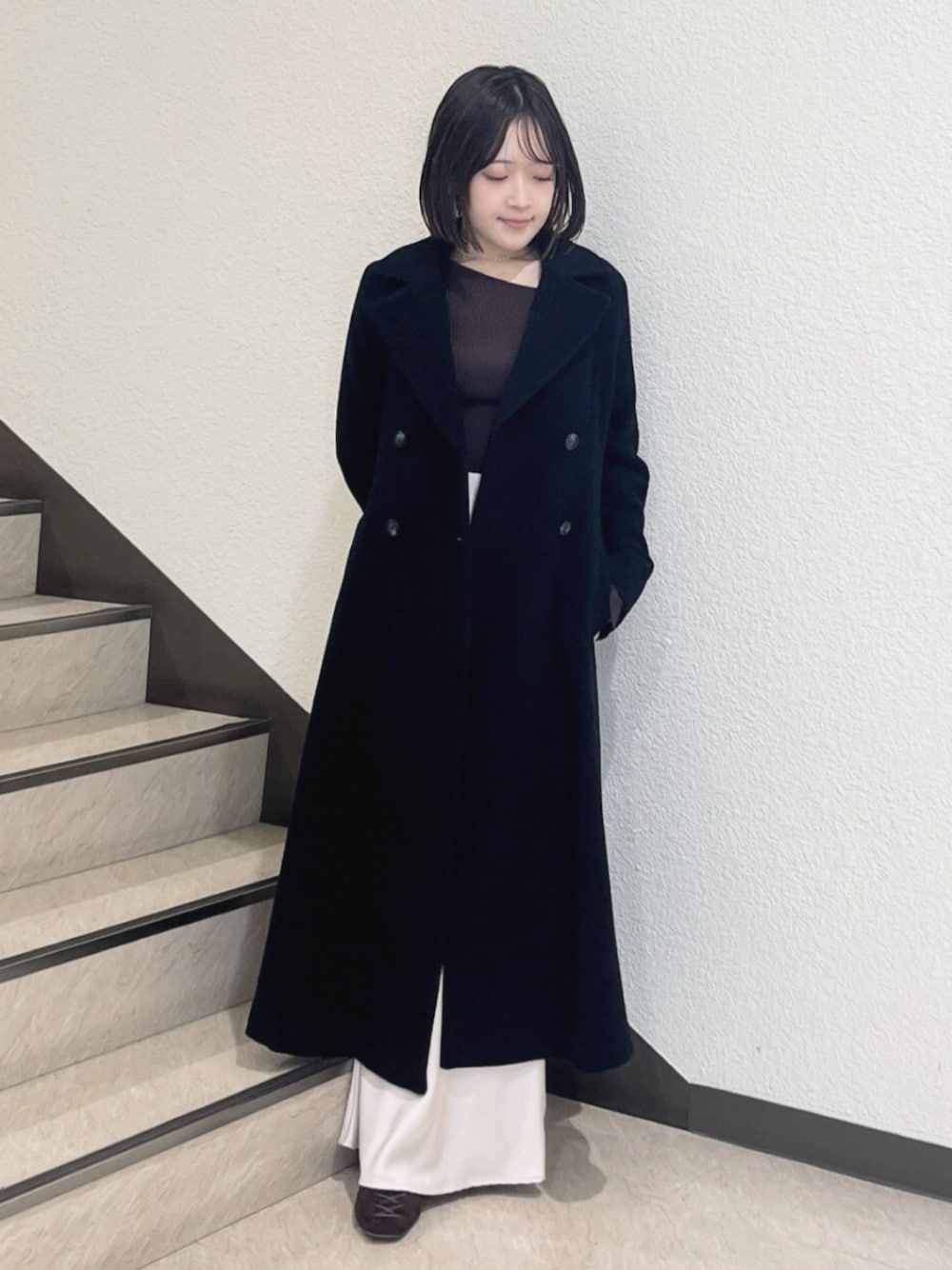 ブラック系のその他アウター、ブラウン系のニット/セーター、ピンク系のスカートを着用したレディースの秋コーディネートの1枚目の写真