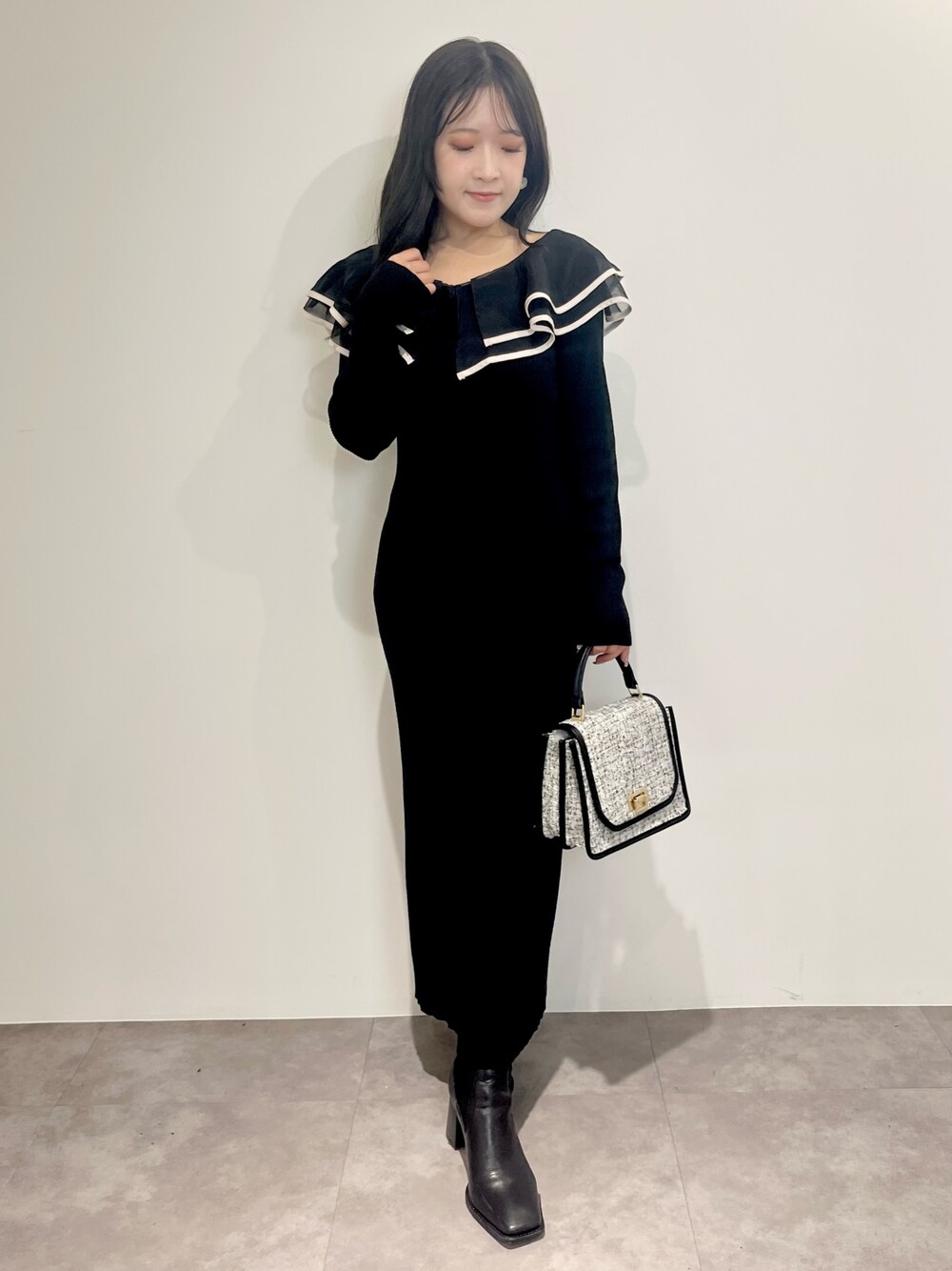 ブラック系のワンピース、ブラック系のショルダーバッグ、ブラック系のブーツを着用したレディースの冬コーディネートの1枚目の写真