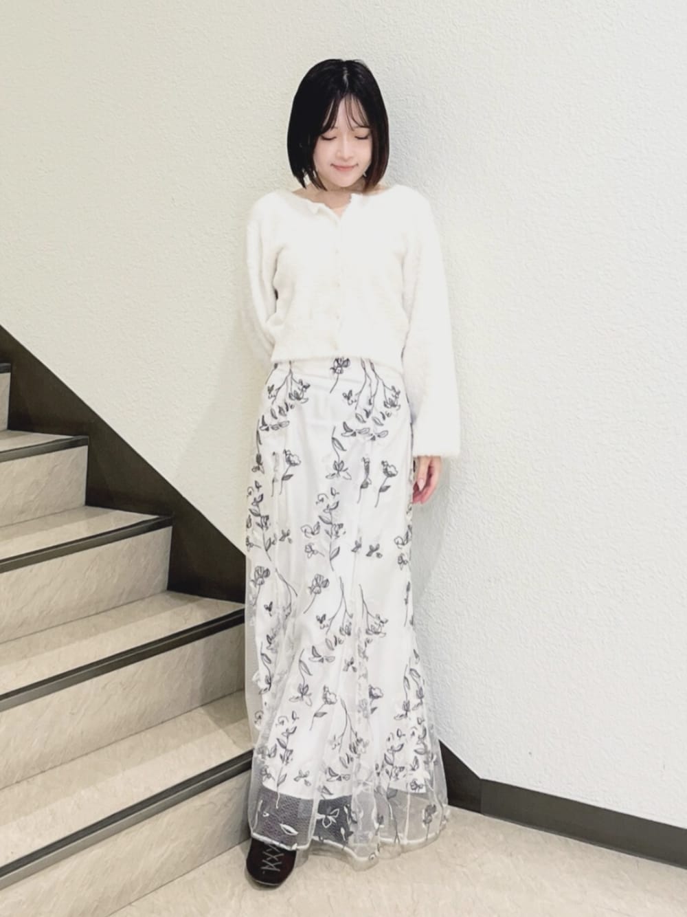 ホワイト系のスカート、ホワイト系のカーディガン/ボレロを着用したレディースの秋コーディネートの1枚目の写真