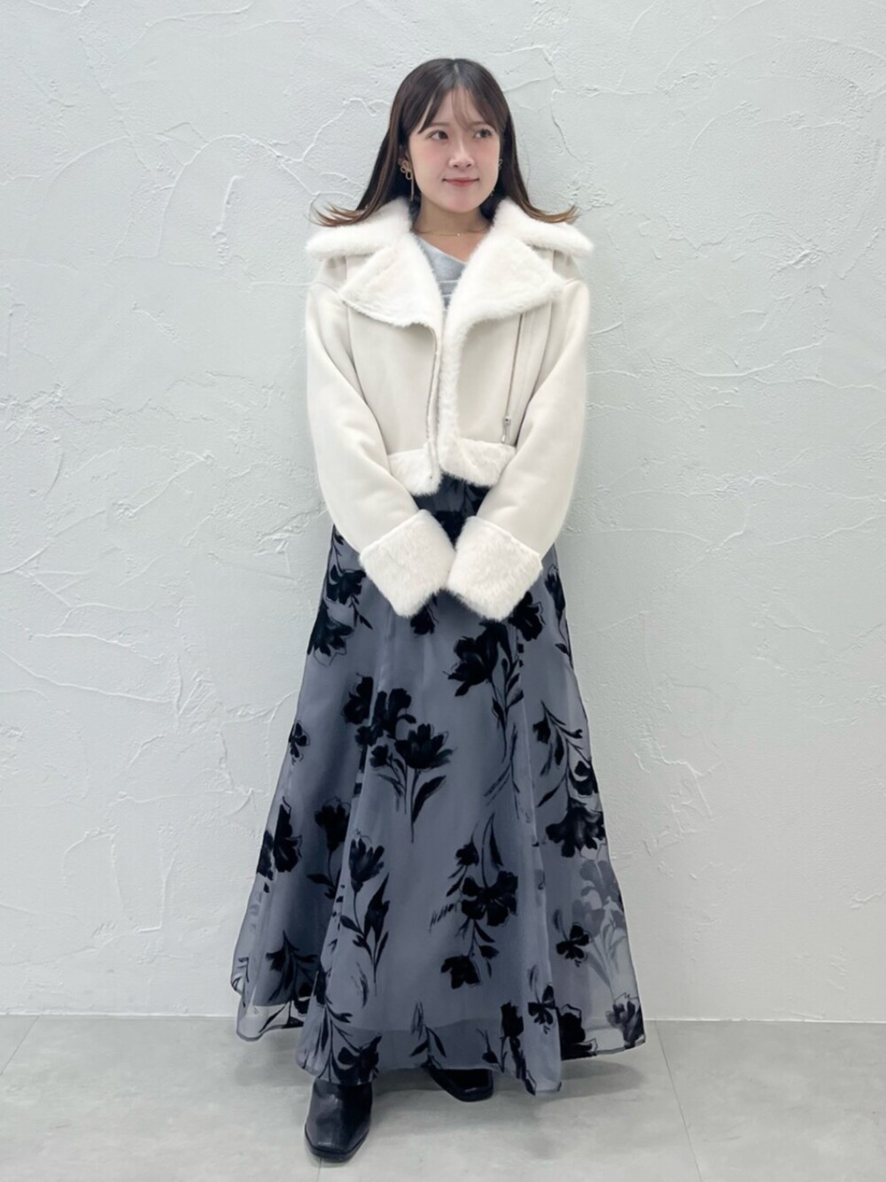 ブラック系のブーツ、ホワイト系のムートンコート、グレー系のニット/セーターを着用したレディースの秋コーディネートの1枚目の写真